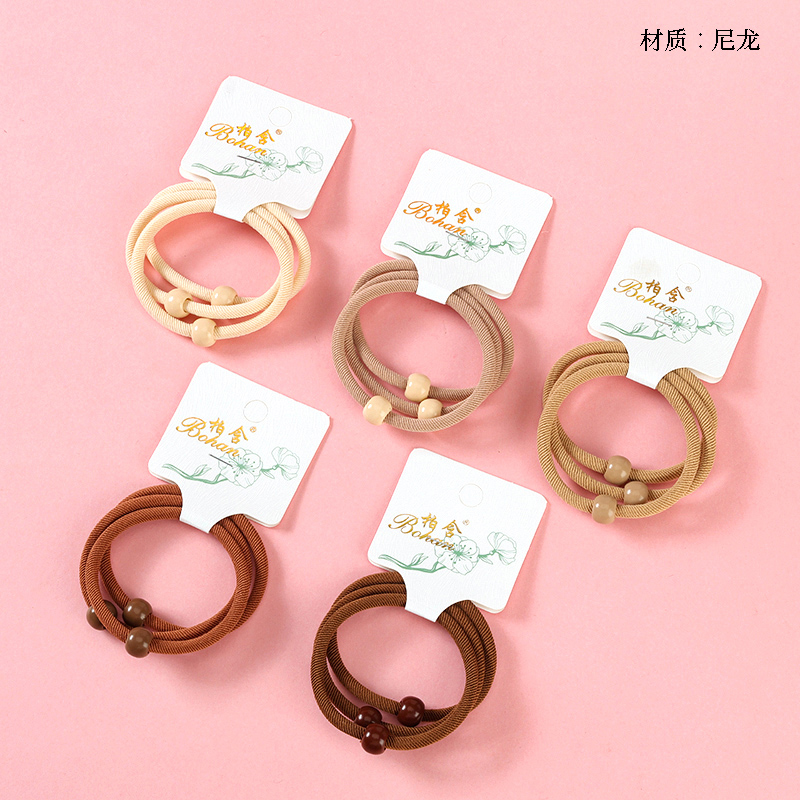 Three curry colored beads threaded rubber band