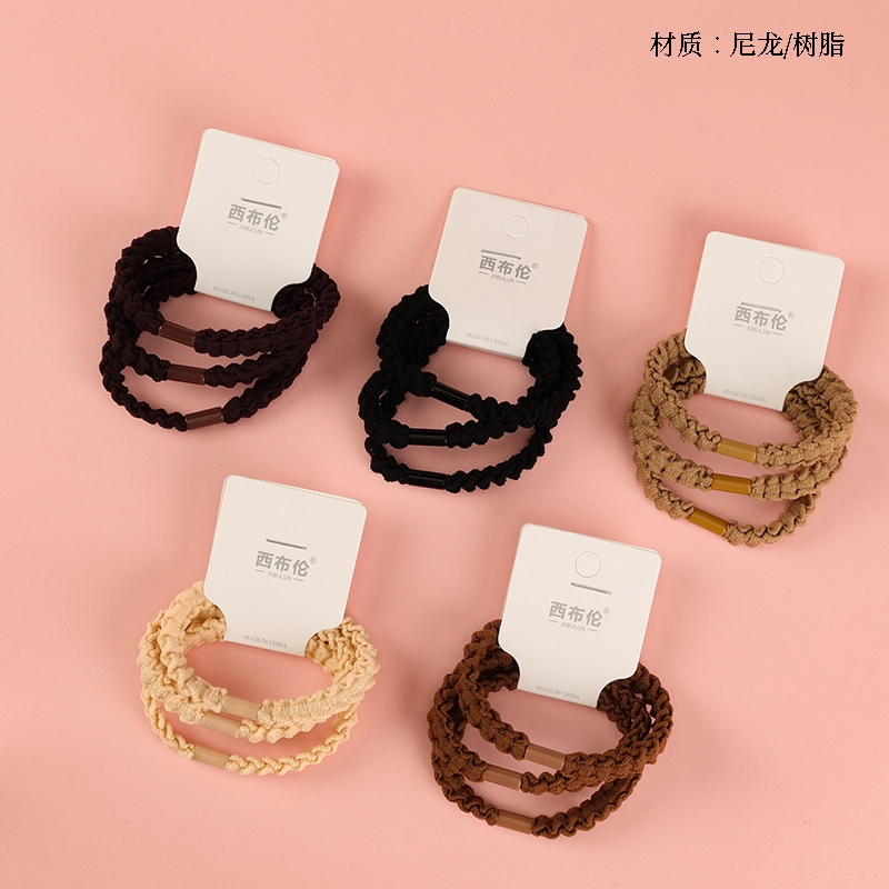 Three creamy colored ruffled rubber bands